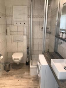 ein Bad mit einem WC, einer Dusche und einem Waschbecken in der Unterkunft Fürstenhof - App. 304 in Sassnitz