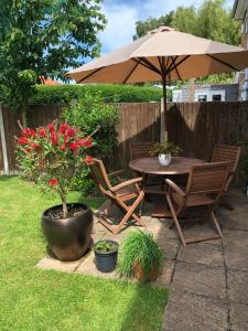 a table and chairs and an umbrella in a yard at Jonan House in Deal