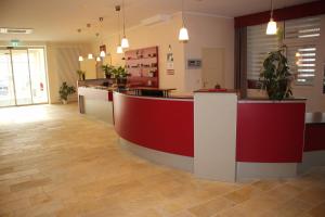 a lobby with a red and white counter with potted plants at Bed & Breakfast Hotel Müllerhof in Caputh