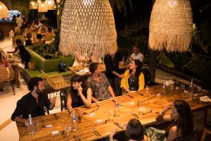 a group of people sitting around a table in a restaurant at Kapuhala Koh Samui- Vegan Boutique Hotel in Chaweng Noi Beach