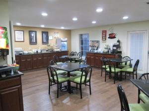 a dining room with tables and chairs and a kitchen at SureStay Plus Hotel by Best Western Asheboro in Asheboro