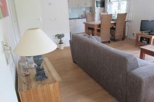 ein Wohnzimmer mit einem Sofa und einem Tisch mit einer Lampe in der Unterkunft Chalet Mi Casita in Voorthuizen