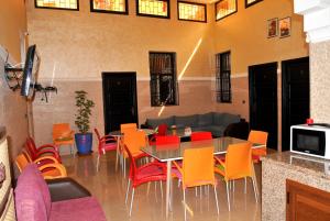 a dining room with a table and colorful chairs at Silia in Marrakesh