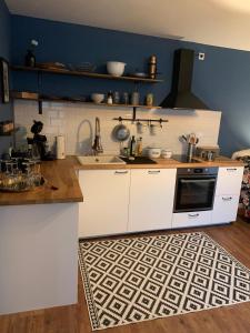 a kitchen with white cabinets and a sink and a kitchen rug at Ferienwohnung Gehl in Monzingen +9 photos