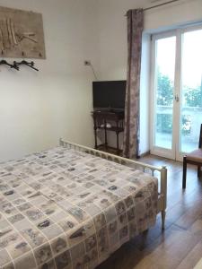 a bedroom with a bed and a piano next to a window at GIARDINO SUL MARE in Amalfi