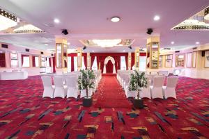 a banquet hall with white chairs and a red carpet at Sachas Hotel Manchester in Manchester