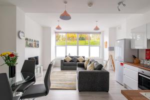 a living room with two couches and a kitchen at Riverside Luxury Apartment in Rochester