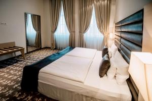 a bedroom with a large bed and a large window at Buda Castle Hotel Budapest in Budapest