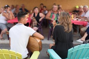 un homme et une femme assis dans des chaises avec un microphone dans l'établissement Camping La Plage Argelès, à Argelès-sur-Mer