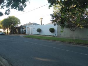 un bâtiment blanc dans une rue avec une route dans l'établissement "La Couronne", à Johannesbourg