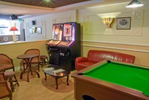 a room with a pool table and a machine at Britannia Hotel Coventry in Coventry