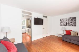Una sala de estar con un sofá y un televisor de pantalla plana. en White City Apartment, en Londres