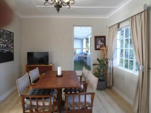 a dining room with a wooden table and chairs at "La Couronne" in Johannesburg