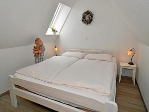 ein Kind steht neben einem Bett in einem Schlafzimmer in der Unterkunft Ferienhof Kragholm in Munkbrarup