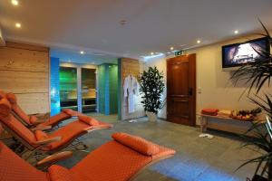 a living room with orange chairs and a flat screen tv at Villa Orania in Bad Gastein