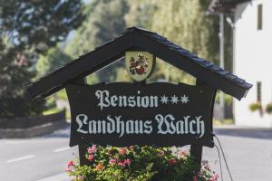 a sign for a school with flowers on a street at Walch's Camping & Landhaus in Braz