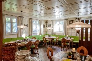 a dining room with tables and chairs and windows at Walch's Camping & Landhaus in Braz