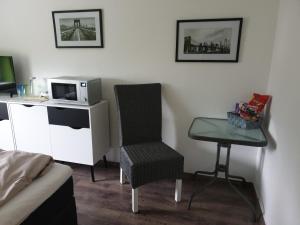 a room with a microwave and a chair and a table at Gästezimmer Haus Talblick in Lautenthal