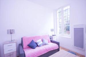 a living room with a pink couch and a window at Superb Quiet And Comfortable Studio Apartment in Paris