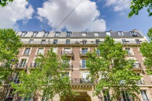 a large brick building with trees in front of it at Nice Apt In Nation ! in Paris