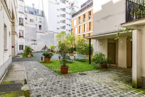 a courtyard with potted plants and buildings at Nice Apt In Nation ! in Paris