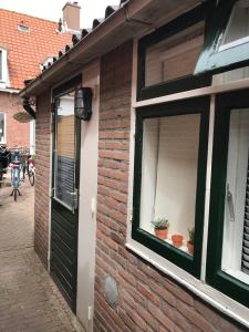 un edificio de ladrillo con una ventana y una puerta en Zoute Zeelucht, en Katwijk aan Zee