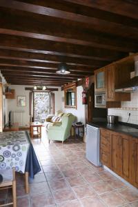 Una cocina y una sala de estar con una mesa y un sofá. en Hotel Rural La Puebla, en Orbaneja del Castillo