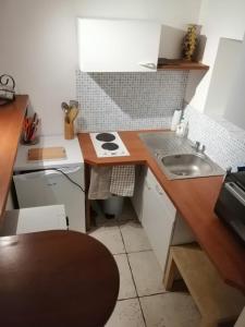 uma pequena cozinha com um lavatório e um fogão em Ty bily em Plaudren