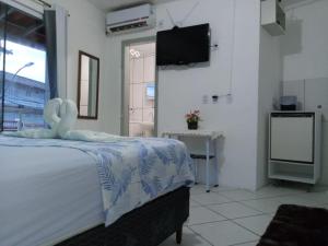 a bedroom with a bed with a towel on it at Pousada do sol in Torres