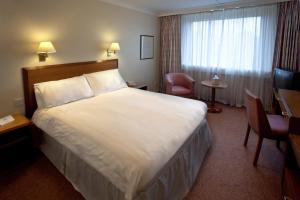 a hotel room with a large bed and a television at Coventry Hill Hotel in Coventry