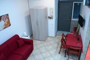 ナポリにあるRostoryのリビングルーム(赤いソファ、テーブル付)