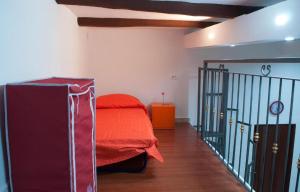 ナポリにあるRostoryのベッドルーム1室(赤毛布付きのベッド1台、階段付)