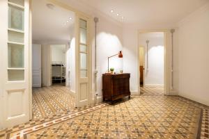 a hallway with white walls and a floor with a lamp at b42 - MODERNIST APARTMENT FOR LARGE GROUPS IN EIXAMPLE in Barcelona