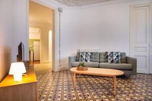 ein Wohnzimmer mit einem Sofa und einem Couchtisch in der Unterkunft b42 - MODERNIST APARTMENT FOR LARGE GROUPS IN EIXAMPLE in Barcelona