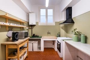 eine Küche mit grünen und weißen Wänden und weißen Arbeitsflächen in der Unterkunft b42 - MODERNIST APARTMENT FOR LARGE GROUPS IN EIXAMPLE in Barcelona