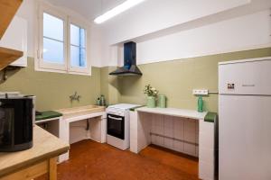 a kitchen with green walls and white appliances at b42 - MODERNIST APARTMENT FOR LARGE GROUPS IN EIXAMPLE in Barcelona