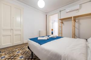 a bedroom with a large bed with towels on it at b42 - MODERNIST APARTMENT FOR LARGE GROUPS IN EIXAMPLE in Barcelona