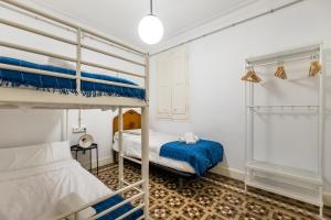 a bedroom with two bunk beds and a table at b42 - MODERNIST APARTMENT FOR LARGE GROUPS IN EIXAMPLE in Barcelona
