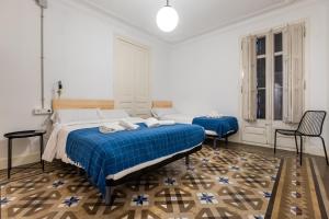 a white bedroom with a blue bed and two chairs at b42 - MODERNIST APARTMENT FOR LARGE GROUPS IN EIXAMPLE in Barcelona