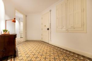 a hallway with white walls and a tile floor and a door at b42 - MODERNIST APARTMENT FOR LARGE GROUPS IN EIXAMPLE in Barcelona