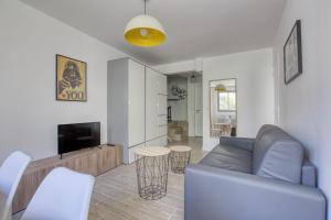 a living room with a couch and a television at Superb Apartment Near The Bassin De La Villette in Paris