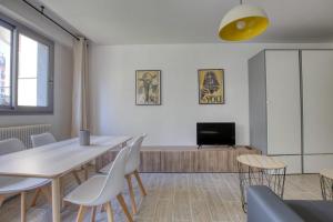 a dining room with a table and chairs and a tv at Superb Apartment Near The Bassin De La Villette in Paris