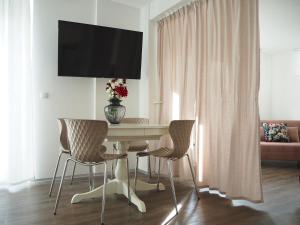 a dining room table with a vase of flowers on top of it at Arthouse Apartment FREE Parking & Self Check-in in Graz