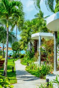 a path through a resort with palm trees at Secret Garden Beach Resort in Bangrak Beach