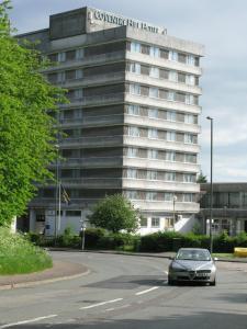 ein Auto, das vor einem Gebäude eine Straße hinunterfährt in der Unterkunft Coventry Hill Hotel in Coventry