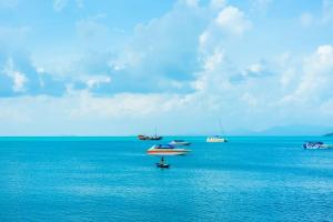 a group of boats sitting in the water at Secret Garden Beach Resort in Bangrak Beach