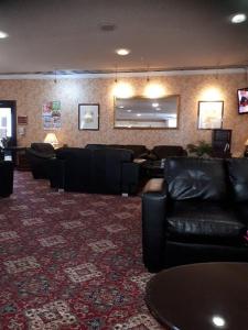 a waiting room with black leather furniture and a mirror at Coventry Hill Hotel in Coventry