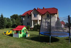 un parque infantil con cama elástica y una casa en Zajazd nad Wisłą, en Dobrzyków