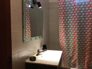 a bathroom with a sink and a shower curtain at CASA JUDITE in Faro