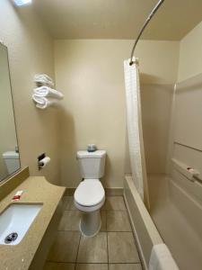 a bathroom with a toilet and a sink and a tub at Lodge Inn Wrightstown - Fort Dix in Wrightstown